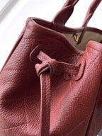 Burgundy Chanel handbag interior view with drawstring tie and stitched lining