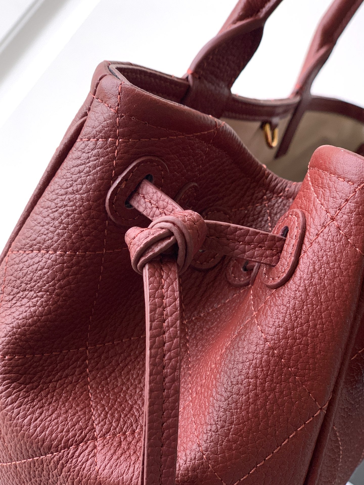 Burgundy Chanel handbag interior view with drawstring tie and stitched lining