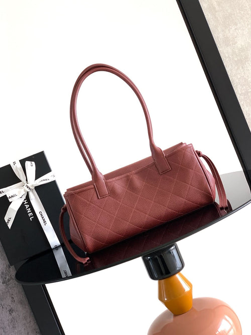 Burgundy Chanel handbag with top handles and quilted leather texture