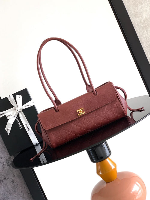 Burgundy Chanel handbag with top handles, front flap, and gold CC clasp