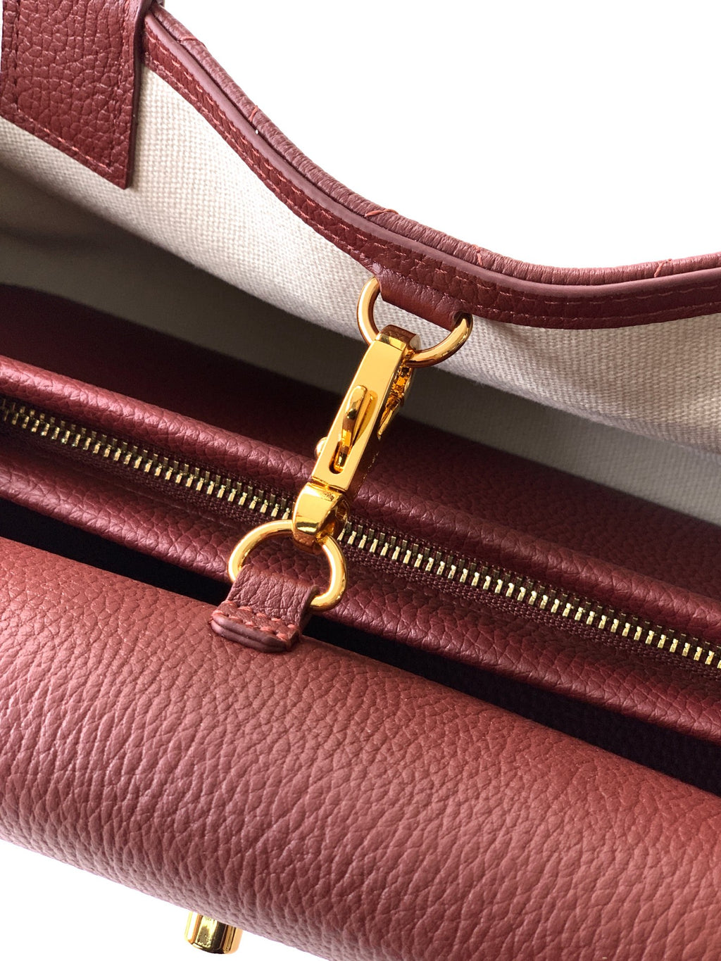 Burgundy Chanel handbag with gold zipper pull and turn-lock clasp detail