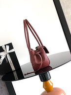 Burgundy Chanel handbag with dual top handles and gold-tone hardware