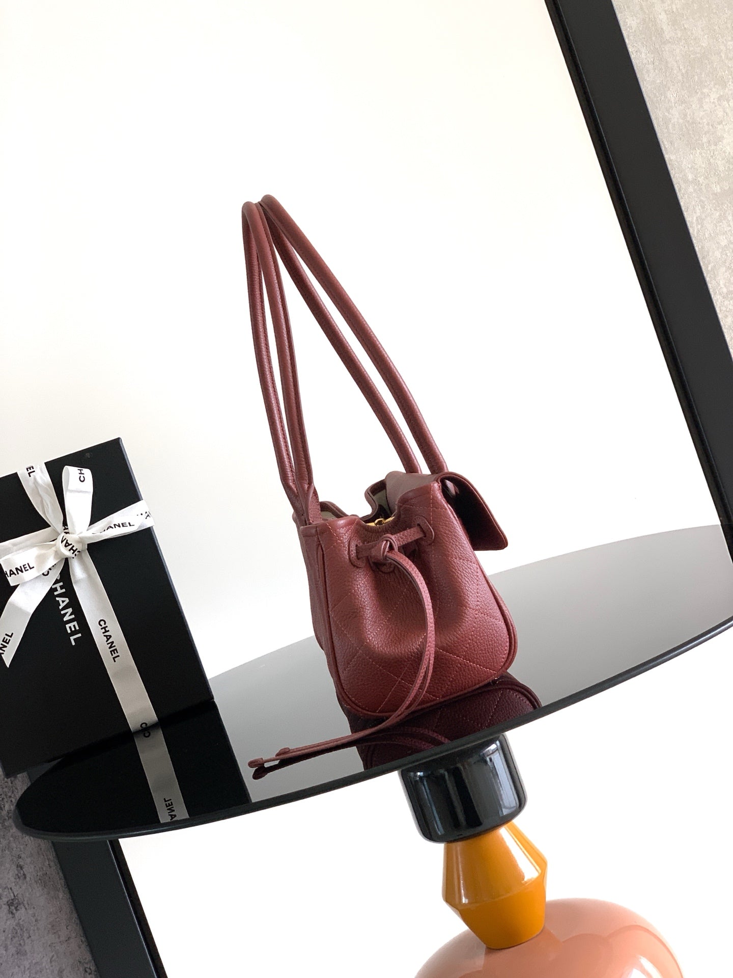 Burgundy Chanel handbag with dual top handles and gold-tone hardware