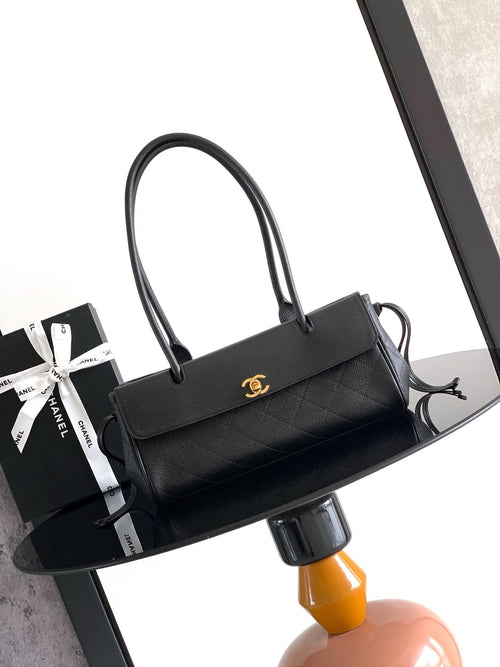 Black quilted leather handbag with top handles and gold Chanel CC clasp