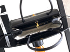 Black leather handbag opened to show interior lining and gold zipper pulls