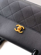Black pebbled leather handbag with gold Chanel CC logo on front flap