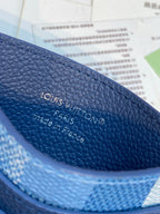 Blue leather card holder close-up with “Louis Vuitton” embossed