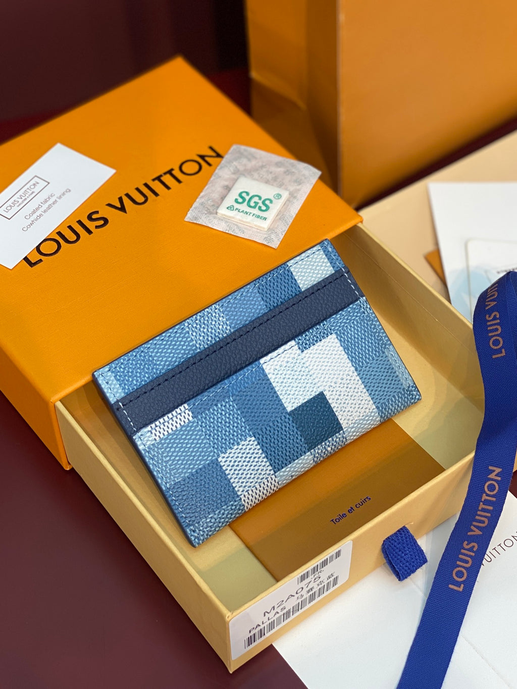 Blue checkered card holder with navy edge trim and slim rectangular shape