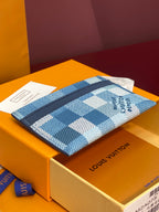 Blue checkered card holder on its box, with navy trim and wrist strap