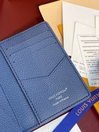 Blue leather card holder front with stitching and Louis Vuitton logo near bottom