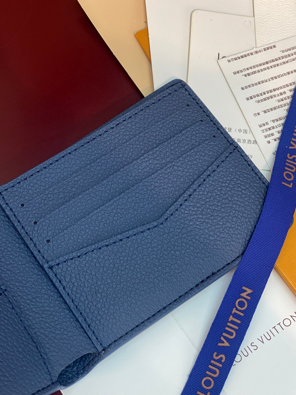 Louis Vuitton blue leather card holder, close-up of front card pocket and stitching