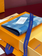 Louis Vuitton blue checkered canvas wallet-style bag on box with blue ribbon