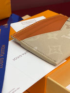 Louis Vuitton small card holder angled view with beige monogram canvas and tan leather top