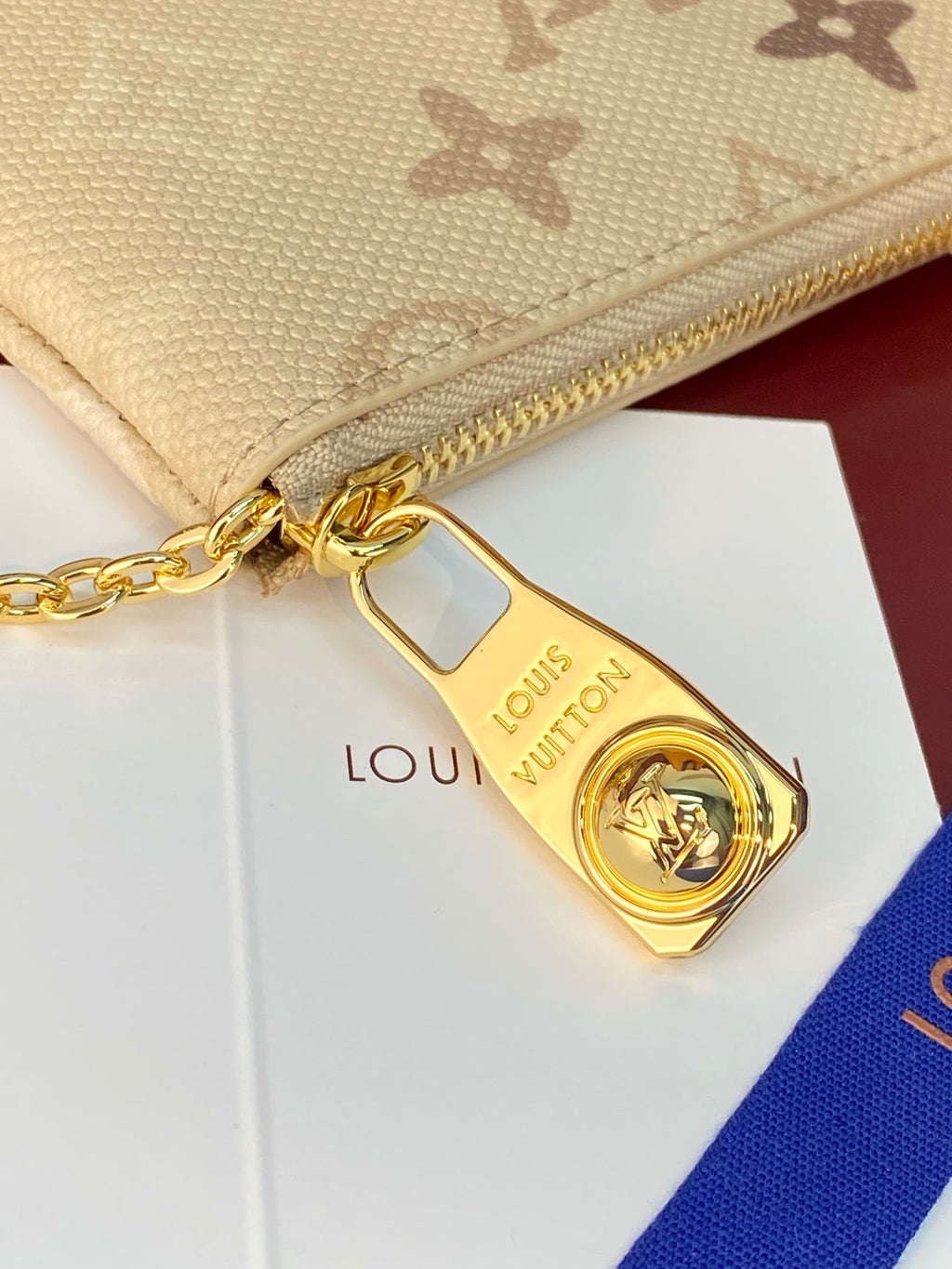 Louis Vuitton gold-tone chain and charm on beige monogram zip pouch