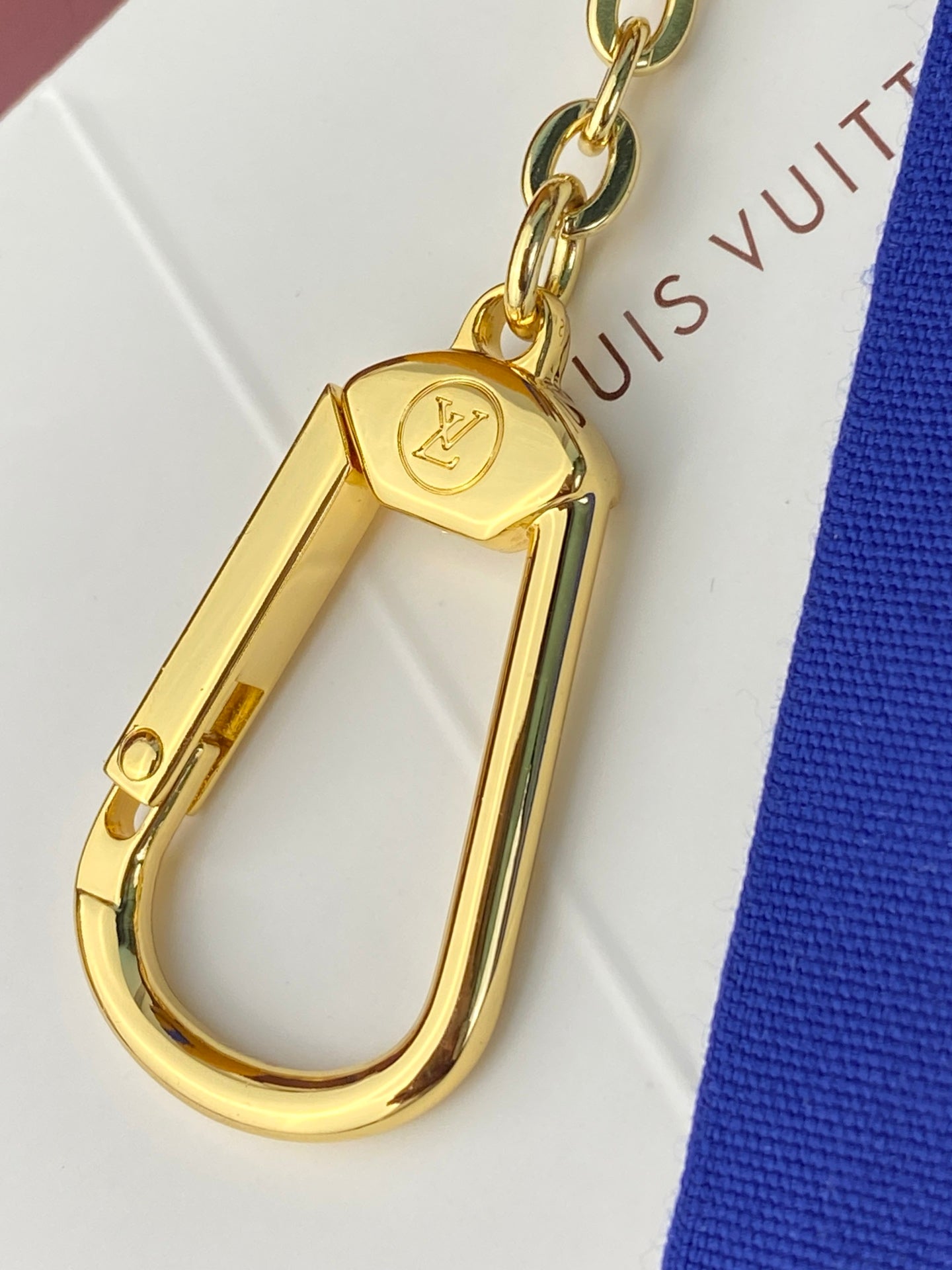 Gold-tone key clasp hardware with chain attachment for a small pouch