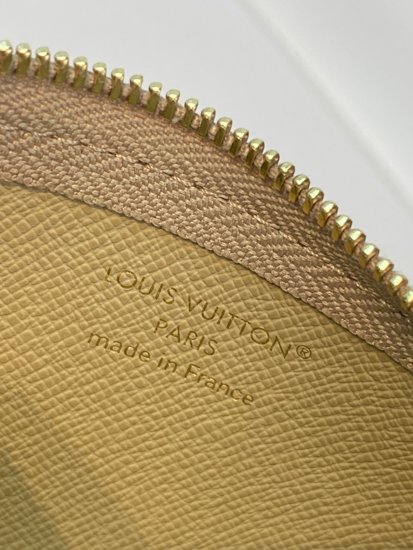 Louis Vuitton leather interior logo stamp and gold zipper edge close-up