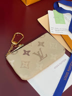 Louis Vuitton beige monogram wrist pouch with gold-tone keyring and zipper