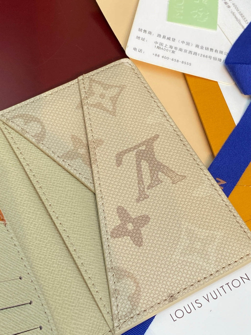 Beige monogram wallet front panel with card slots and logo print