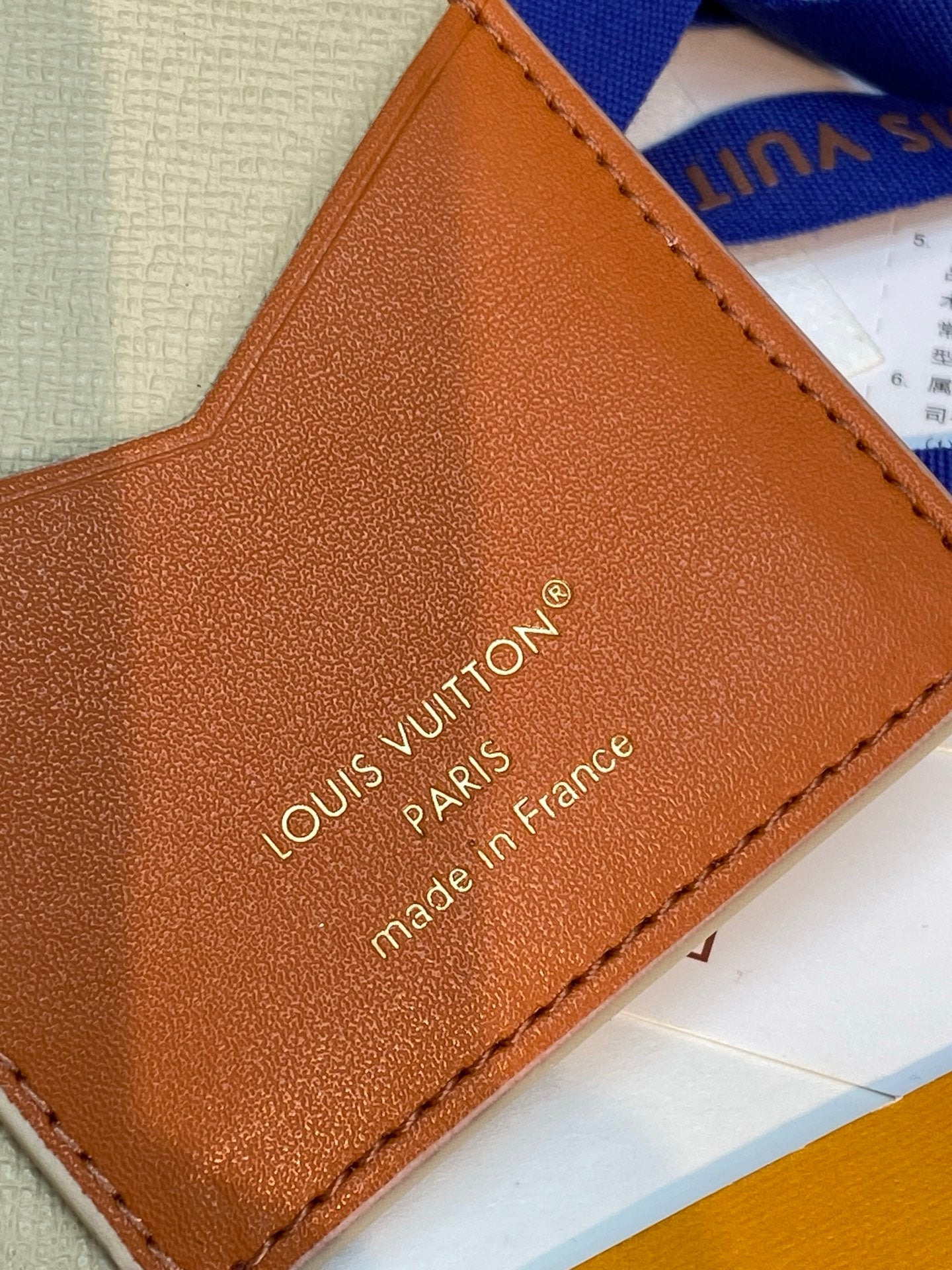 Orange leather card panel with Louis Vuitton PARIS text and stitched border