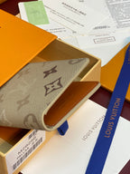 Monogram card holder folded, beige canvas cover with brown icons and orange interior
