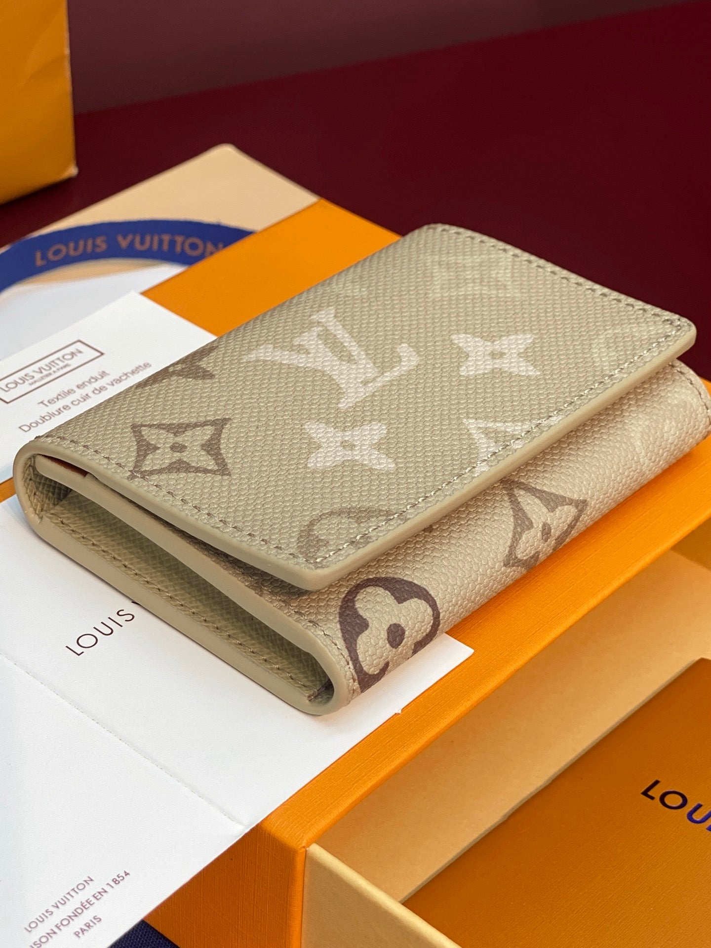 Light beige Louis Vuitton monogram card holder with curved folded edge