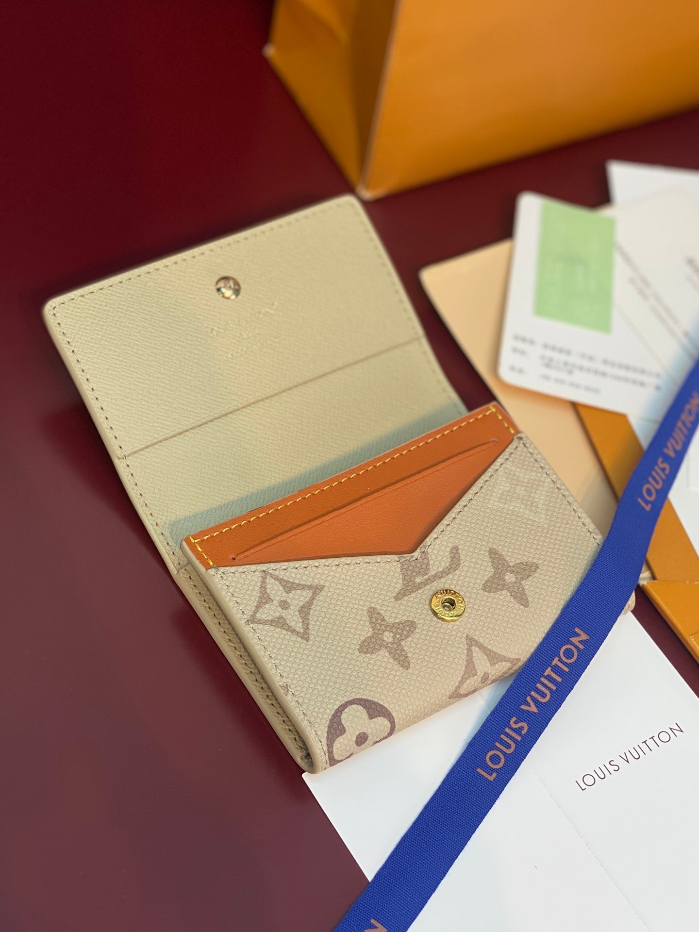 Beige Louis Vuitton monogram wallet with orange insert, front flap and gold snap