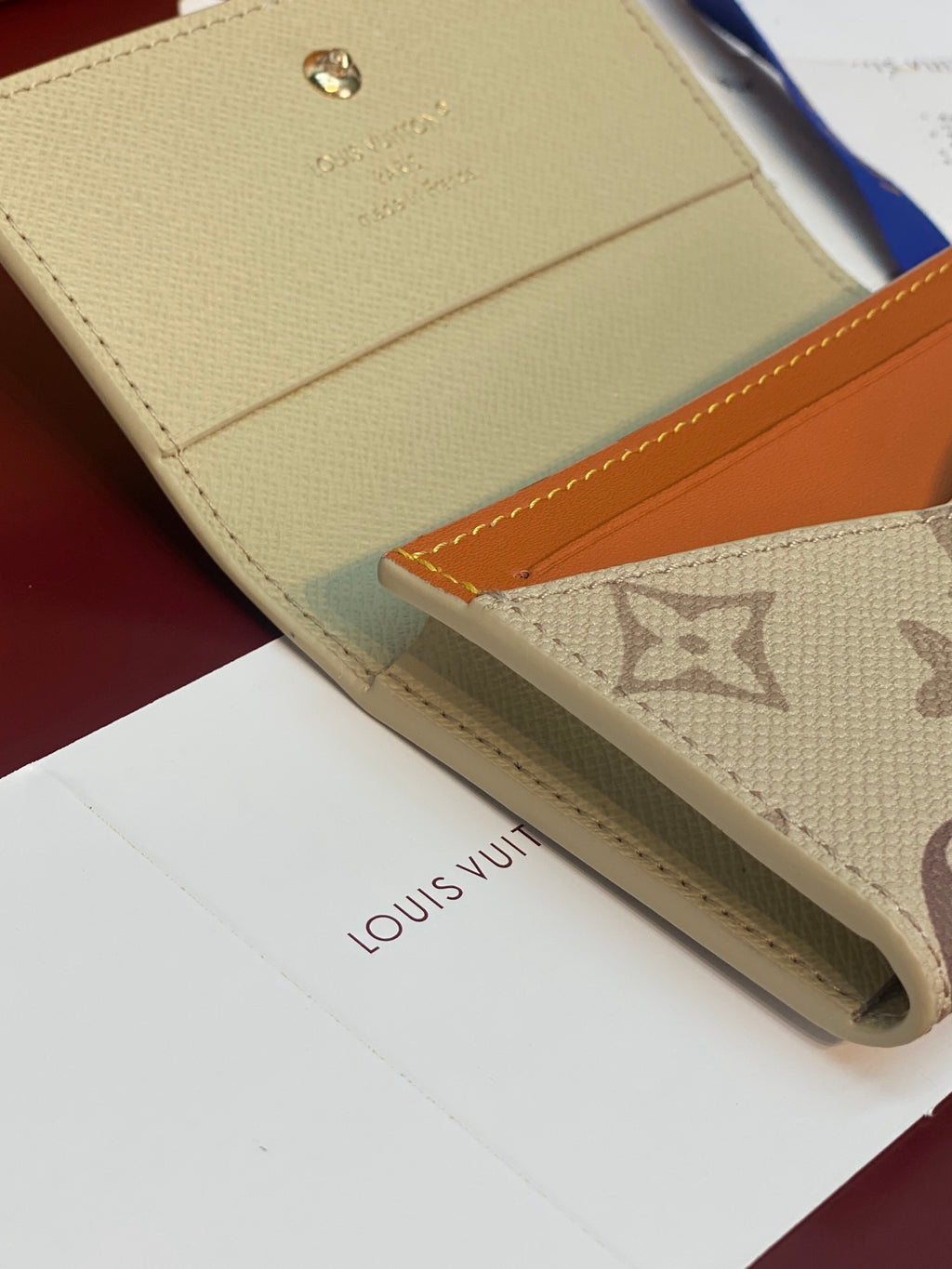 Beige Louis Vuitton monogram wallet edge with orange leather pocket