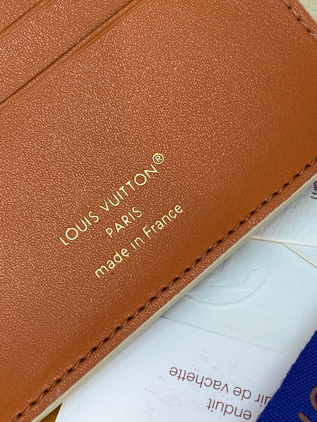 Louis Vuitton small bag close-up of tan leather branding and stitched border