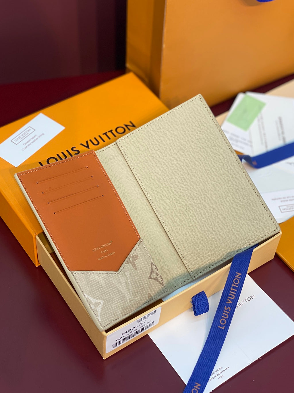 Beige Louis Vuitton monogram card holder with orange interior card slots