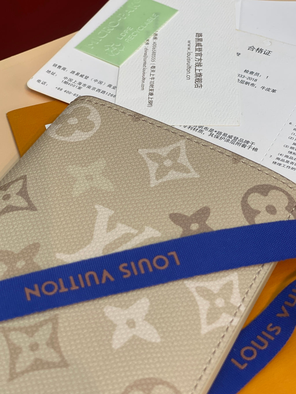 Louis Vuitton monogram card holder with blue stripe detail, beige canvas
