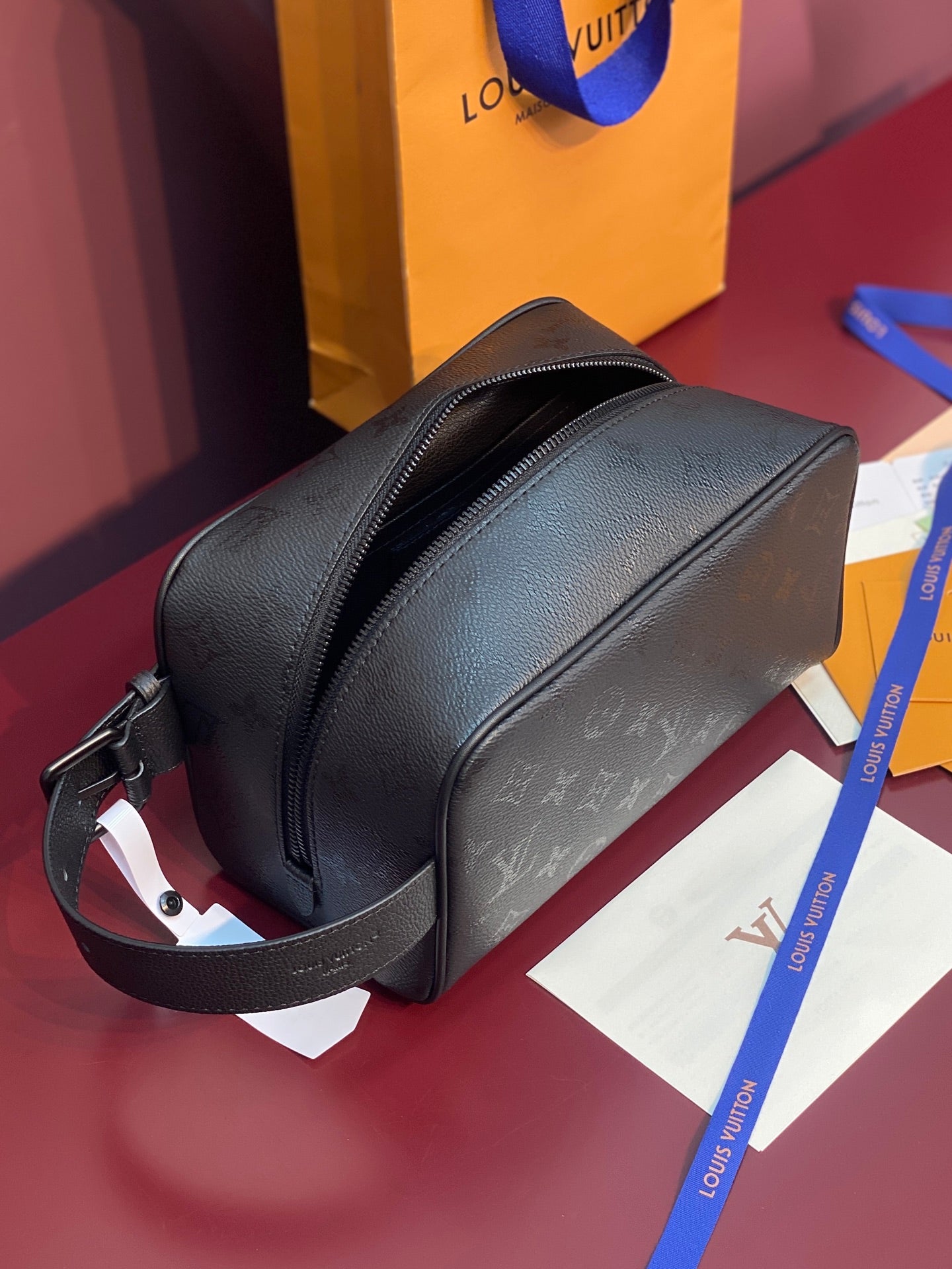 Louis Vuitton bag, dark textured leather crossbody with front zipper and adjustable strap