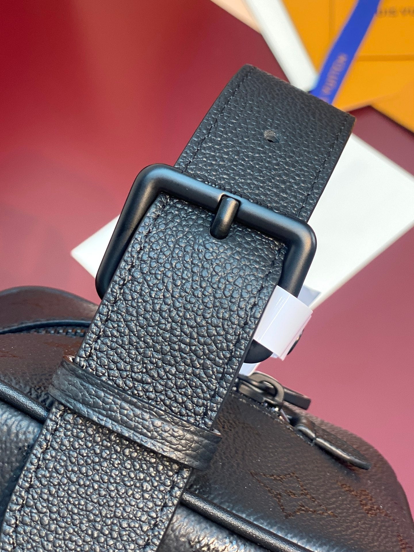 Louis Vuitton bag, dark textured leather with belt-like buckle strap and stitched edge