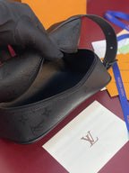 Louis Vuitton bag, dark textured leather close-up of zipper opening and strap attachment