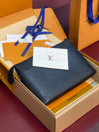 Louis Vuitton leather clutch bag with dark blue monogram texture and zip top; wrist strap attached.