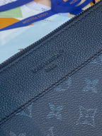 Louis Vuitton dark blue bag close-up showing zipper and embossed monogram texture