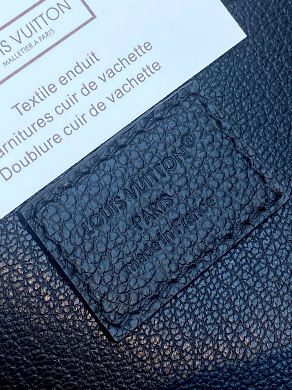 Close-up of Louis Vuitton dark blue textured leather with embossed monogram pattern