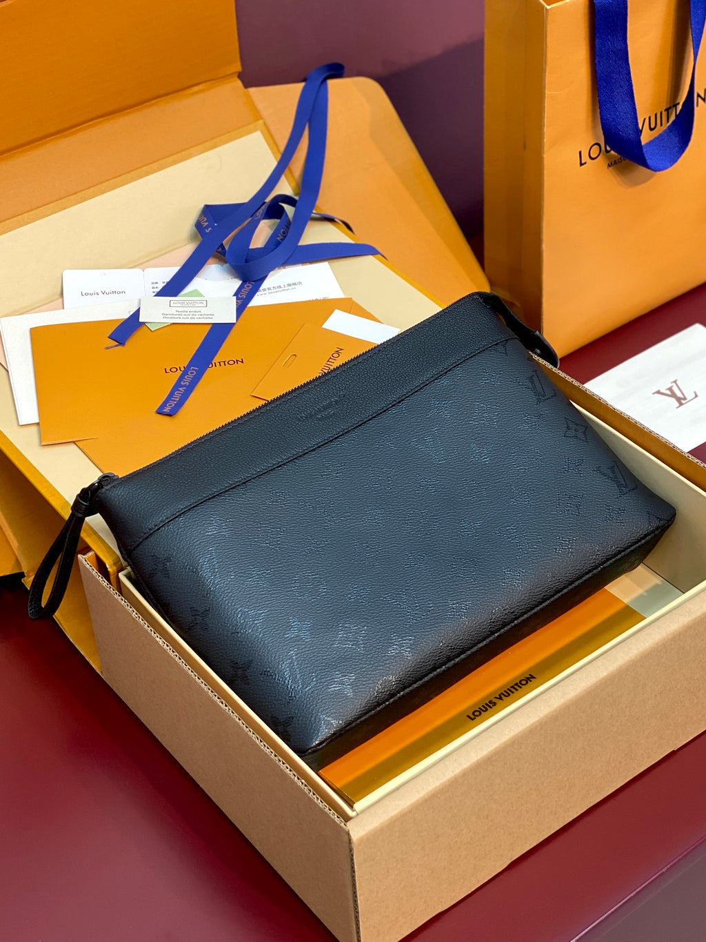 Louis Vuitton small bag in dark blue with textured monogram finish and zip closure