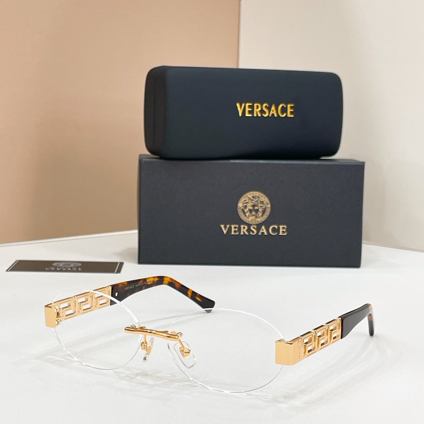 Designer eyeglasses with tortoiseshell arms, gold geometric temples, and clear lenses