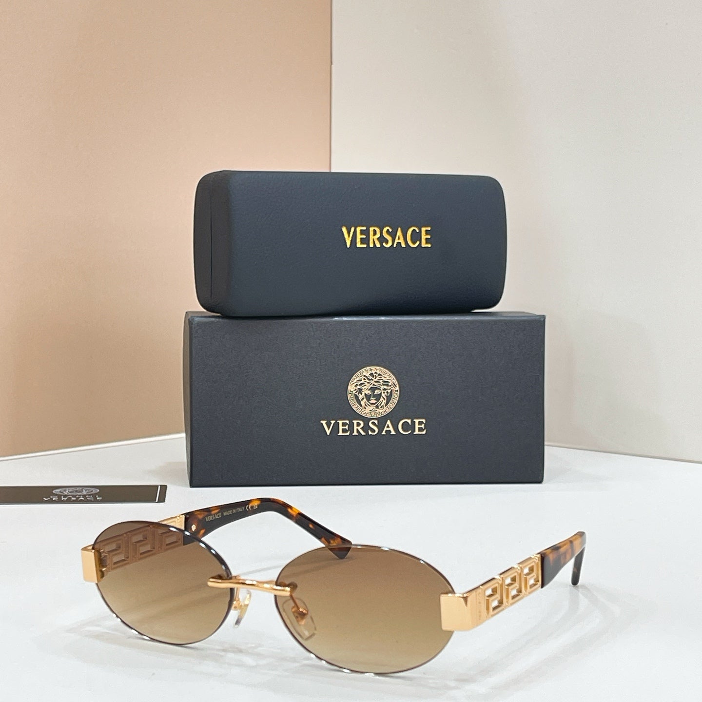 Tortoiseshell and gold designer sunglasses with tinted brown lenses and geometric temples