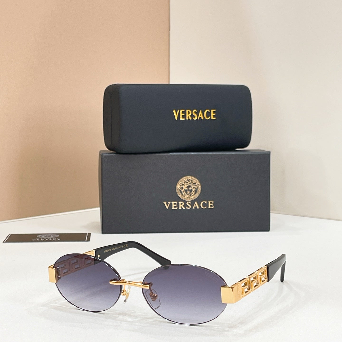 Designer sunglasses with purple lenses, black frame, and gold geometric temple detail