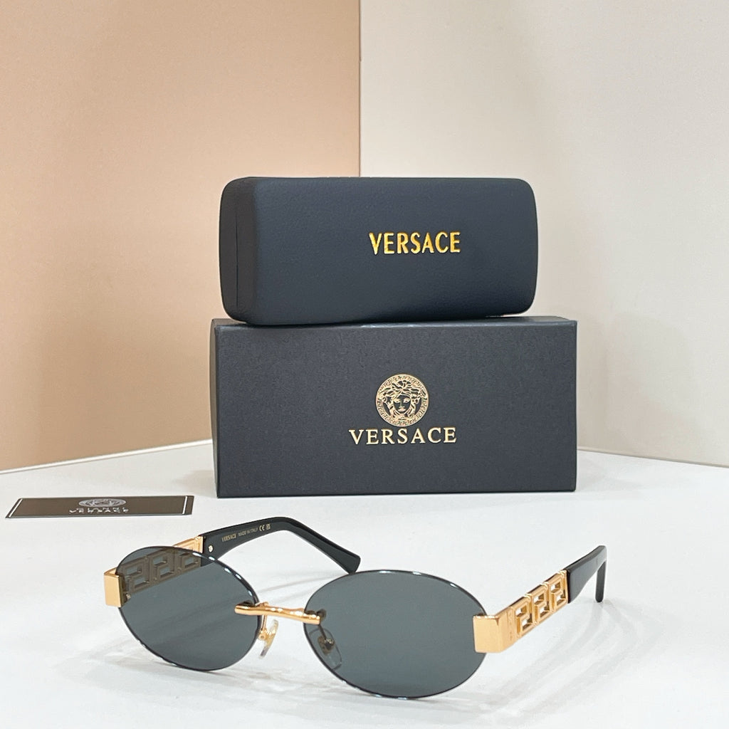 Designer sunglasses with dark blue lenses, black frame, and gold geometric temple detail