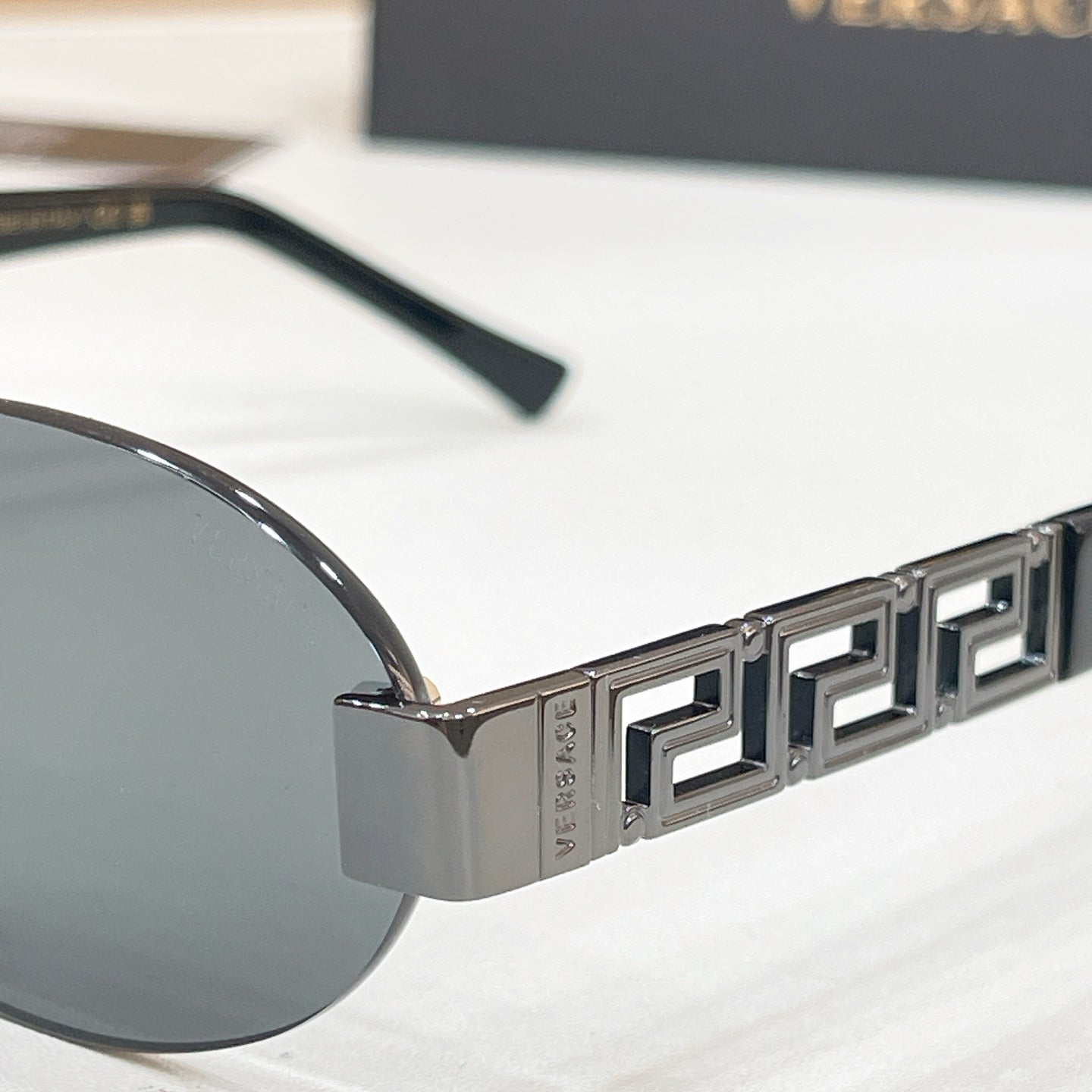 Versace sunglasses temple close-up with Greek key pattern and metal logo detail