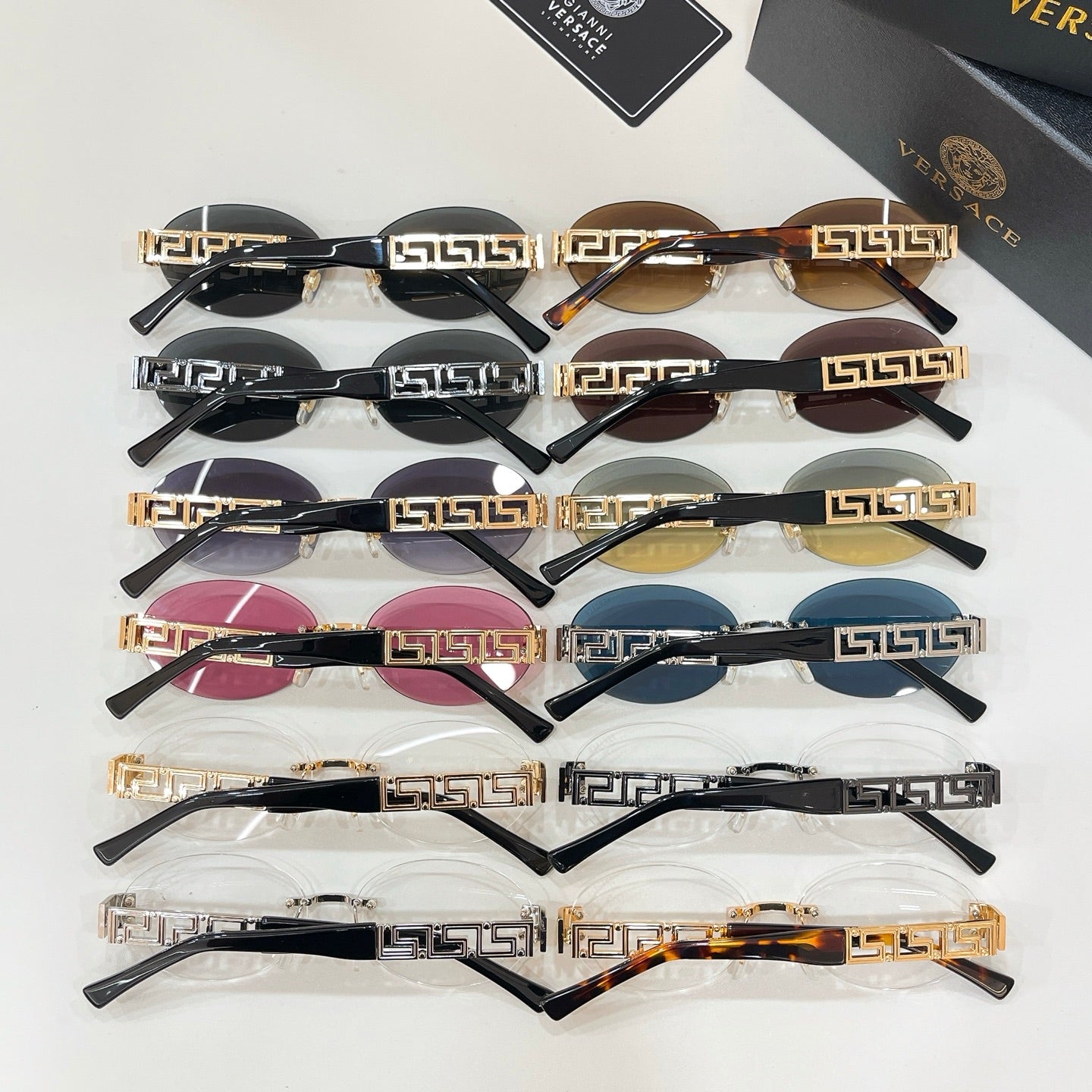 Versace sunglasses assortment with black frames, Greek key detailing, and colored lenses