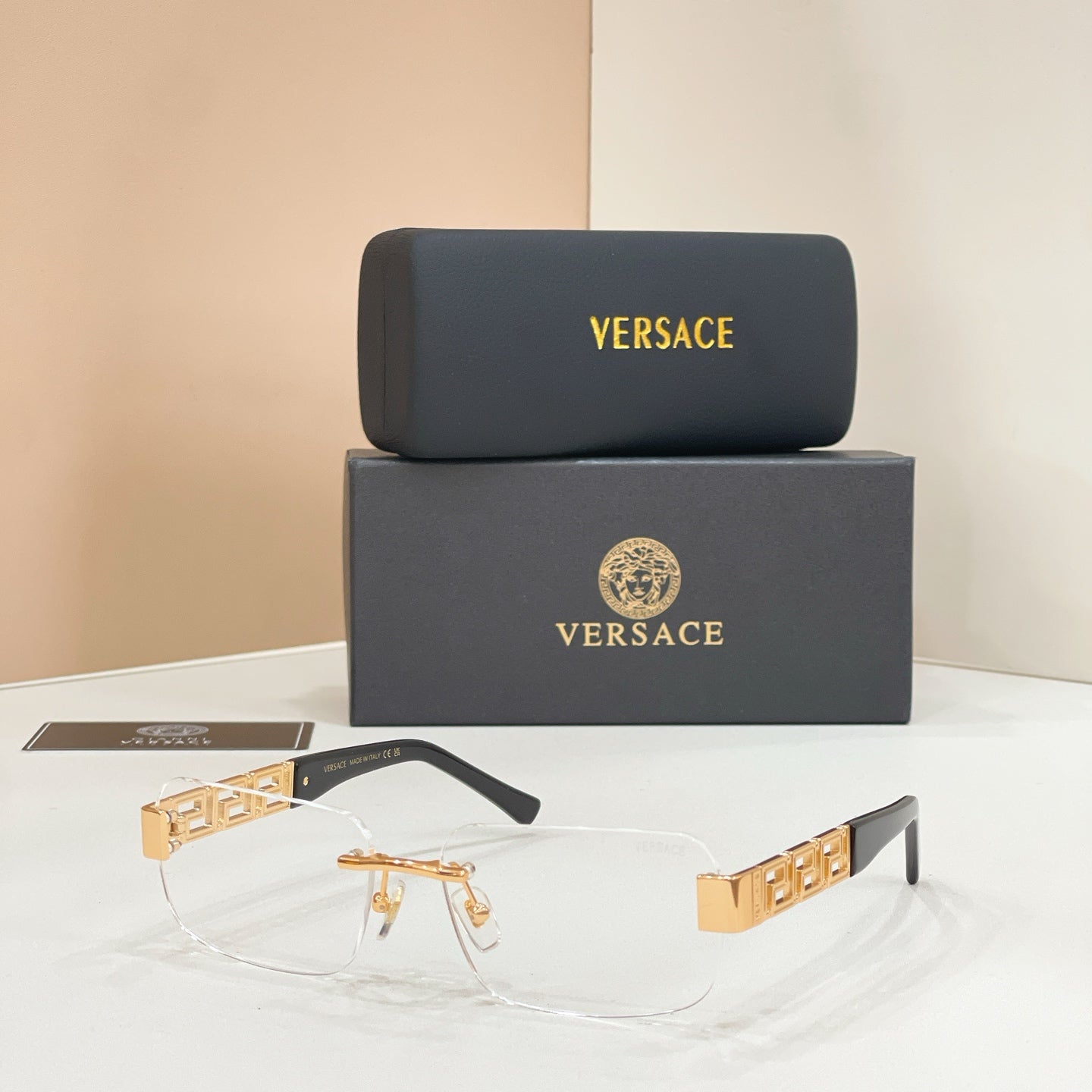 Sunglasses with clear lenses, gold-tone metal frame, dark temple accents