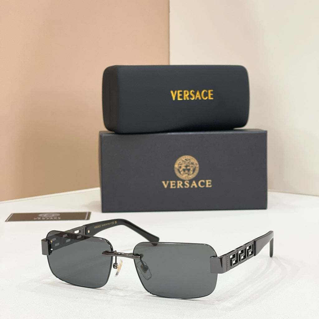 Sunglasses with gray tinted lenses, gold-tone metal frame, dark temple accents