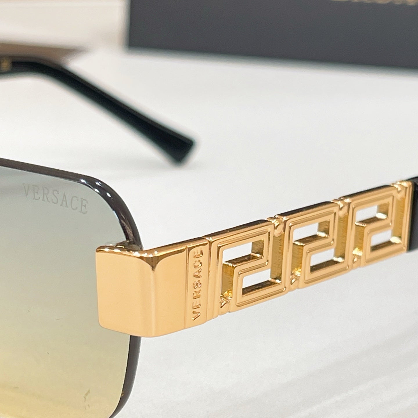 Gold Versace sunglasses temple with Greek-key pattern and cutout link detail