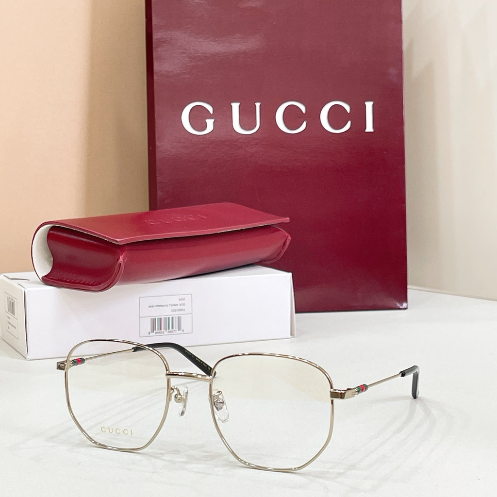 Gold-tone and black full-rim eyeglasses with clear lenses and red-green enamel pins