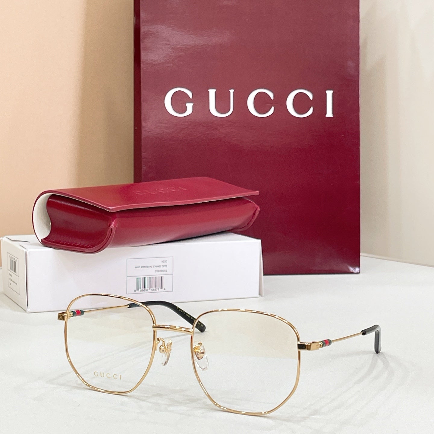 Gold-tone and black full-rim eyeglasses with clear lenses and red-green detail