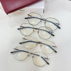 Set of four clear-lens eyeglasses with gold-tone frames, black temples, multicolor accents