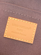 Leather brand label on small monogram pouch bag: Louis Vuitton Paris, made in France